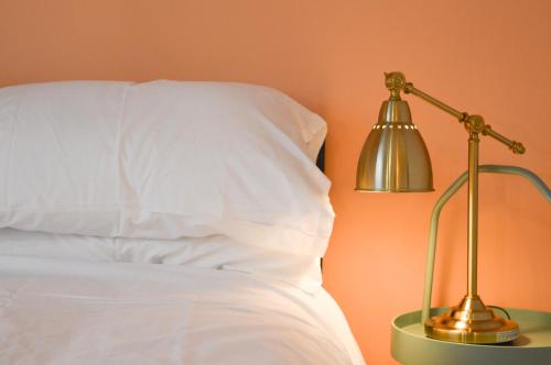 a bed with a silver lamp next to a white pillow at The Bristol Wing in Bristol