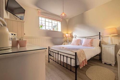 a bedroom with a bed with pink pillows on it at The Ship At Dunwich in Dunwich