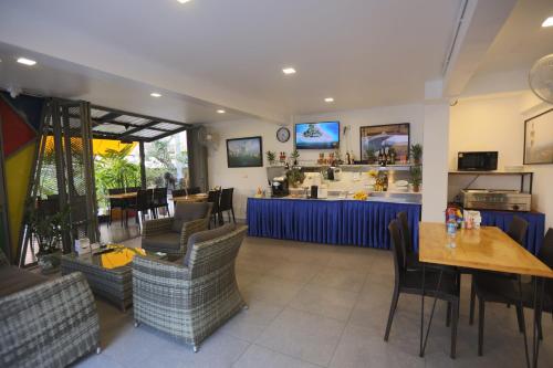 ein Restaurant mit einem Tisch und Stühlen sowie einer Bar in der Unterkunft Hotel Montha in Chiang Mai