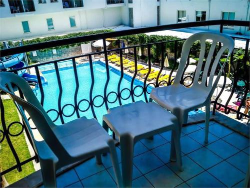 a balcony with two chairs and a swimming pool at BESO BEACH HOTEL in Agva