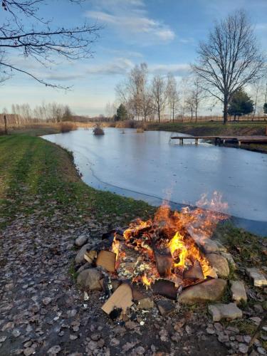 a bonfire on the rocks next to a river at Ranczo Rykowisko in Kołodzieje