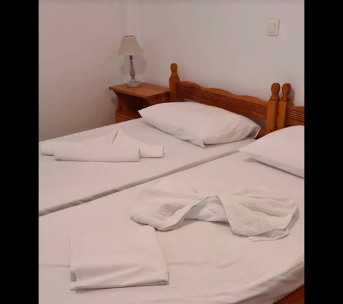 two twin beds with white sheets and pillows at Akti Rooms And Studios in Livadion