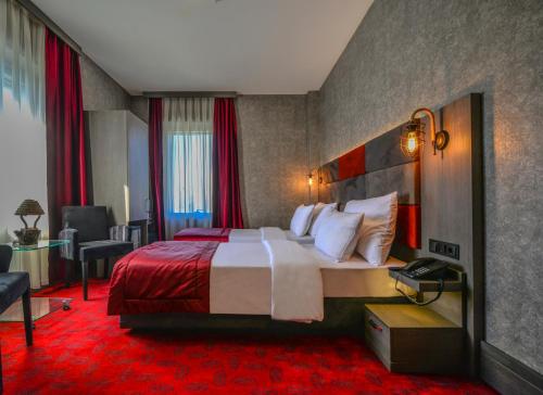 Habitación de hotel con cama grande y alfombra roja en A11 Hotel Atasehir, en Estambul
