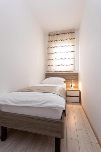 a bedroom with a large bed and a window at Apartments Crnekovic Tomislava 8 in Baška