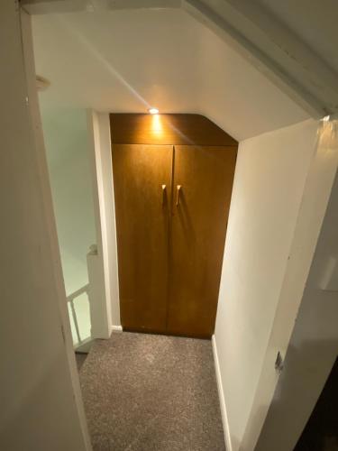 a hallway with a wooden door in a room at The Attic En-suite Room in Plymouth