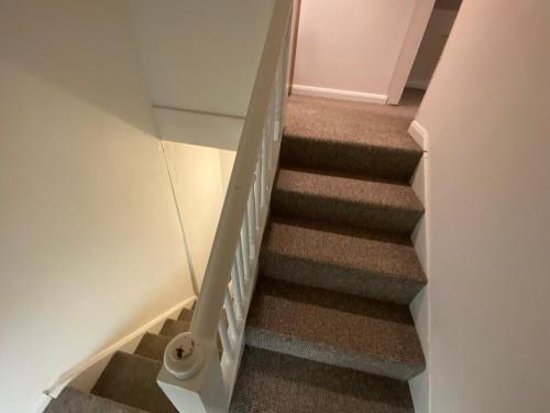 a stairwell with a glass railing and stairs with a stair case at The Attic En-suite Room in Plymouth