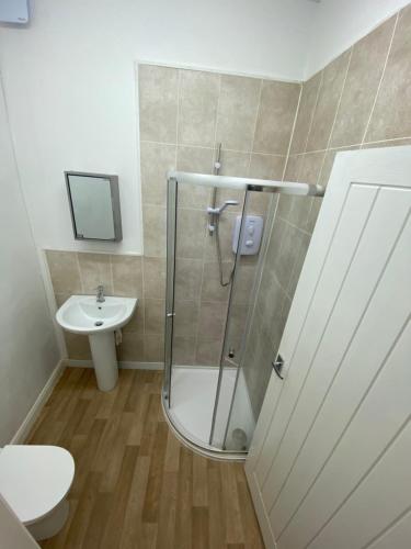 a bathroom with a shower and a toilet and a sink at The Attic En-suite Room in Plymouth