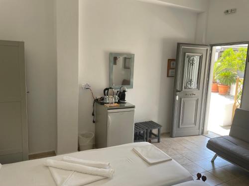 a white room with a bed and a mirror at Akti Rooms And Studios in Livadion