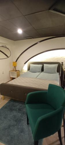 a bedroom with a large bed and a green chair at 10 PERCENT OFF UNTIL 31ST OF OCTOBER - Old Café Spa Apartment in Belgrade