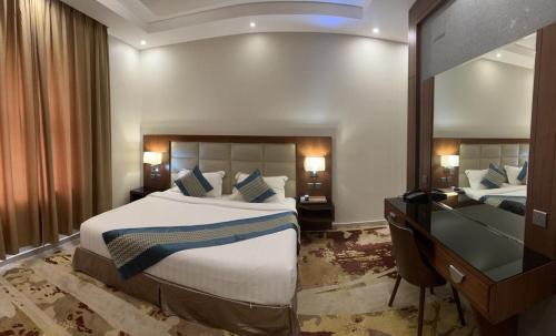 a hotel room with a large bed and a desk at Delta Hotel Suites in Jazan