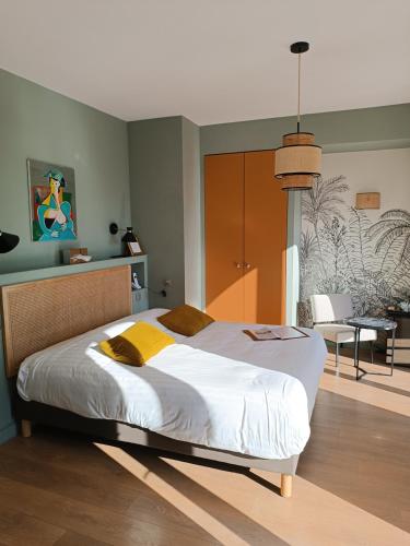 a bedroom with a large bed and a dining room at Les Galets Hôtel et B&B in Bandol