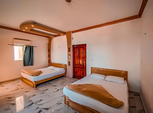- une chambre avec 2 lits et une fenêtre dans l'établissement Zarnouk beach house, à Dahab