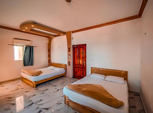 une chambre avec deux lits et une fenêtre dans l'établissement Zarnouk beach house, à Dahab