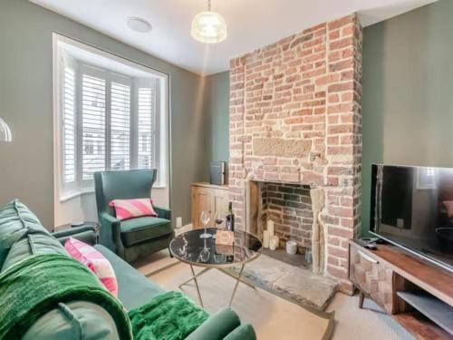a living room with a couch and a fireplace at Stoney Nook Cottage in Guisborough