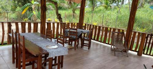 Casa temporada jaguaripe bahia toca do guaiamum في Jaguaripe: شرفة خشبية عليها طاولة وكراسي