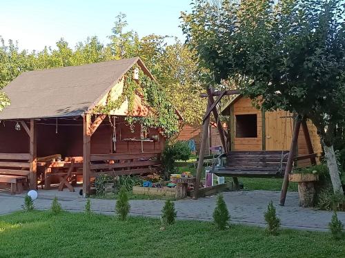 eine Hütte mit einem Tisch und einer Bank im Hof in der Unterkunft Wczasy na Kaszubach u Hani in Wiele