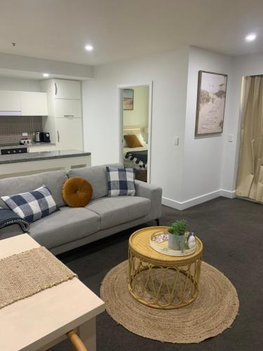 uma sala de estar com um sofá e uma mesa em Pier 108 Glenelg em Glenelg