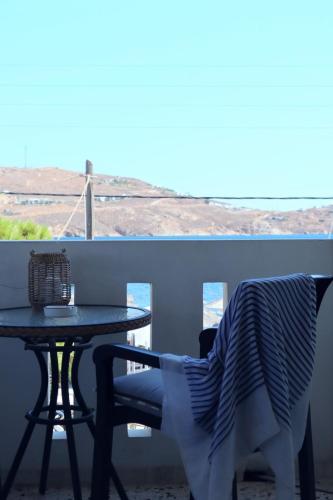 a table and a chair on a balcony with a table at Akti Rooms And Studios in Livadion