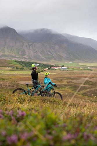 a man and a child on a bike in a field at Soti Lodge in Fljot