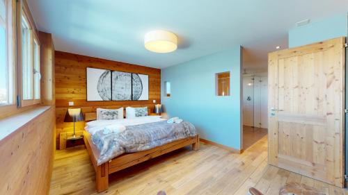 a bedroom with a bed with blue walls and wooden floors at Egg SAUNA & LUXURY chalet 16 pers by Alpvision Résidences in Veysonnaz