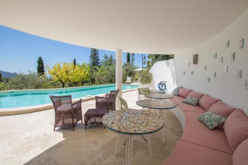 un patio avec tables et chaises et une piscine dans l'établissement Villa Nymphée, à Vaison-la-Romaine