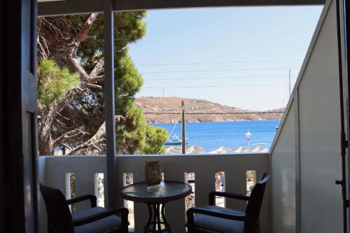 a balcony with a table and chairs and a view of the water at Akti Rooms And Studios in Livadion