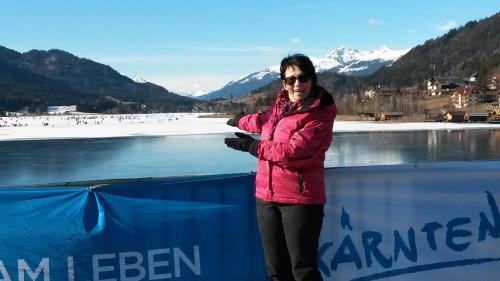 a woman in a pink jacket standing next to a fence at Ferienwohnung Andritsch in Sankt Georgen im Gailtal