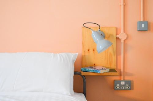 a bed with a white pillow and a blue lamp at The Bristol Wing in Bristol