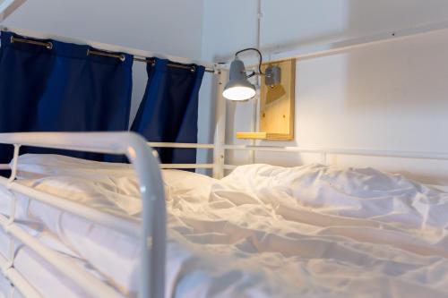 an unmade bed in a hospital room with a blue curtain at The Bristol Wing in Bristol