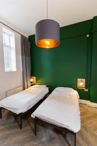 two beds in a room with a green wall at The Bristol Wing in Bristol
