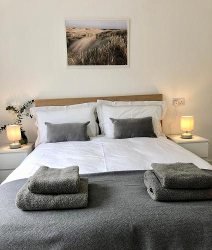 a bedroom with a large white bed with two lamps at Spacious En-suite Private Double Bedroom in Oxford