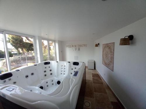 a bathroom with a large white bath tub in a room at Gîte de Fanny du Moulin de Tartay en Avignon in Avignon