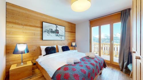 ein Schlafzimmer mit einem Bett mit einer Holzwand in der Unterkunft Egg SAUNA & LUXURY chalet 16 pers by Alpvision Résidences in Veysonnaz