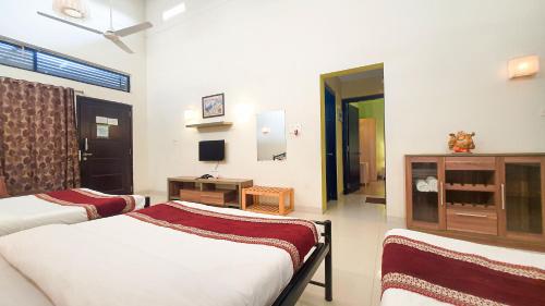 a room with two beds and a television in it at Rainforest Resort and Spa, Igatpuri -Nature's Luxury Awaits in Igatpuri