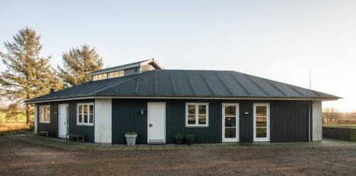 a black and white house with a roof at Guesthouse Tradsborgvej in Tjæreborg