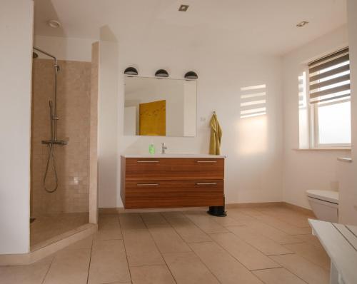 a bathroom with a wooden sink and a shower at Guesthouse Tradsborgvej in Tjæreborg