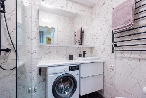 een badkamer met een wasmachine en een wastafel bij Memel Townhouse apartamentai in Klaipėda