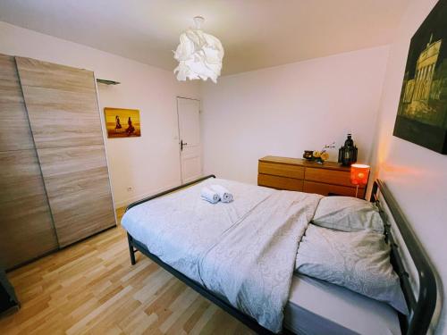 a bedroom with a bed and a dresser at Appartement Sympa entre Paris et Disneyland in Noisy-le-Grand