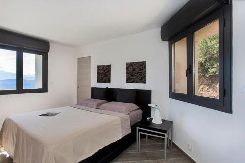 une chambre blanche avec un lit et une fenêtre dans l'établissement Le SAN PETRONE-TOUR EN PIERRE EN CENTRE CORSE ENTRE MER ET MONTAGNE, à Moltifao