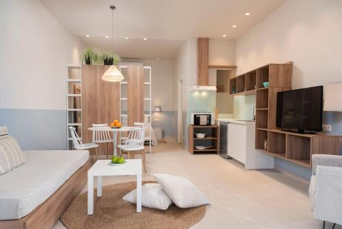 a living room with a white couch and a kitchen at A , Seaview Pearl ,Stalida in Stalida