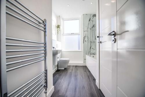 een badkamer met een douche, een toilet en een deur bij Apartment 4 - The Crescent in York