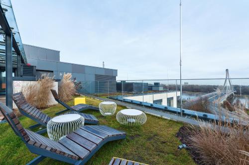 a park with benches and tables and a building at Flisac Apartment by LoftAffair in Warsaw