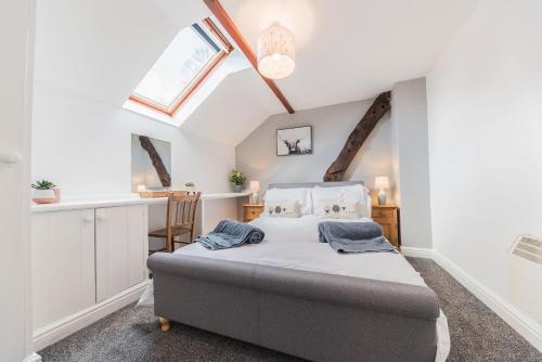 um quarto com uma cama e uma janela em Byre Cottage Woodland Coniston em Torver