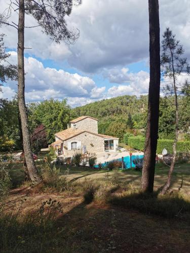 a house in the middle of a yard with trees at DOMAINE DES 3 CYPRÈS Chambre PIVOINE Chez Nath & Pat in Fumel