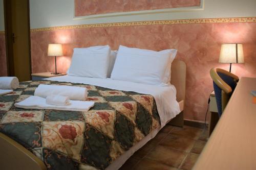 a hotel room with a bed with two towels on it at Hostel il Tetto in Melfi