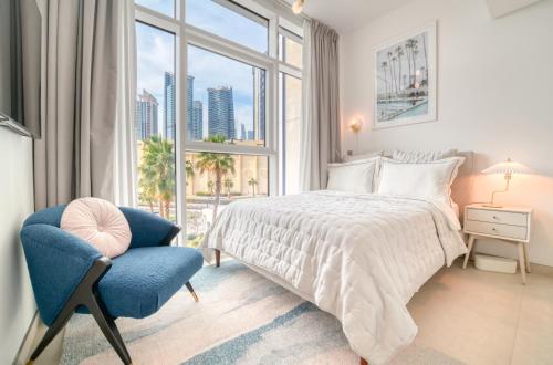 a bedroom with a bed and a chair and a window at Studio with City Views, Jumeirah Lake Towers - Mint Stay in Dubai