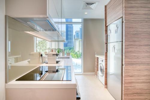 a kitchen with white appliances and a large window at Studio with City Views, Jumeirah Lake Towers - Mint Stay in Dubai