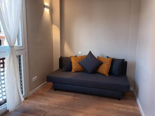 a couch sitting in a room with a window at La Casona del Eboni in Alcalá de Henares