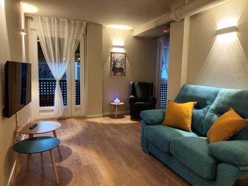 a living room with a blue couch and a chair at La Casona del Eboni in Alcalá de Henares