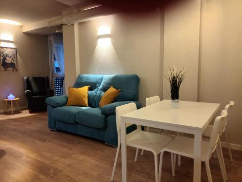 a living room with a blue couch and a table at La Casona del Eboni in Alcalá de Henares